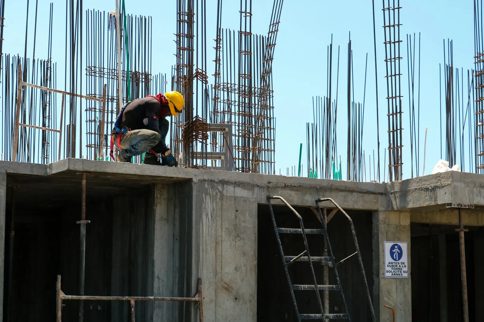 Operário sobre a estrutura de concreto e vergalhões do Galpão Industrial Vale